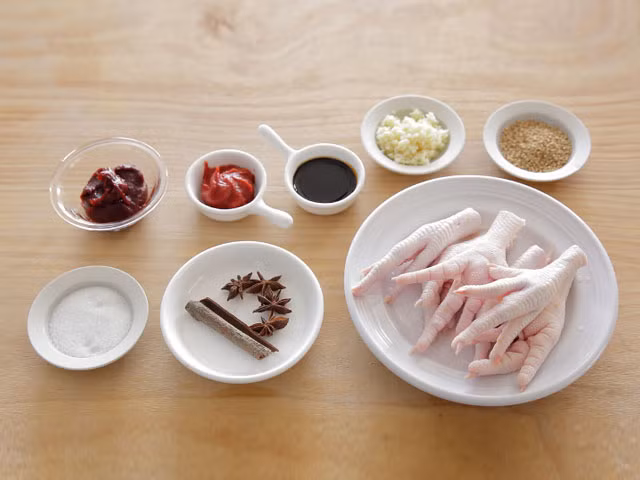 Nguyên liệu cho món chân gà cay khá đơn giản: 200g chân gà, 2 hoa hồi, 5g quế, ½ thìa sốt tương đen, ½ thìa sốt cà chua ketchup, 50g ớt Hàn Quốc, 1 thìa đường, 1 thìa tỏi băm, 1 thìa hạt vừng (mè). 