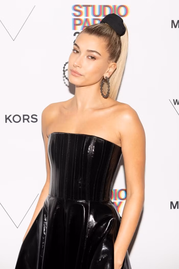 Hailey Baldwin dùng chun buộc cao mái tóc dài khoe bờ vai và lưng gợi cảm.