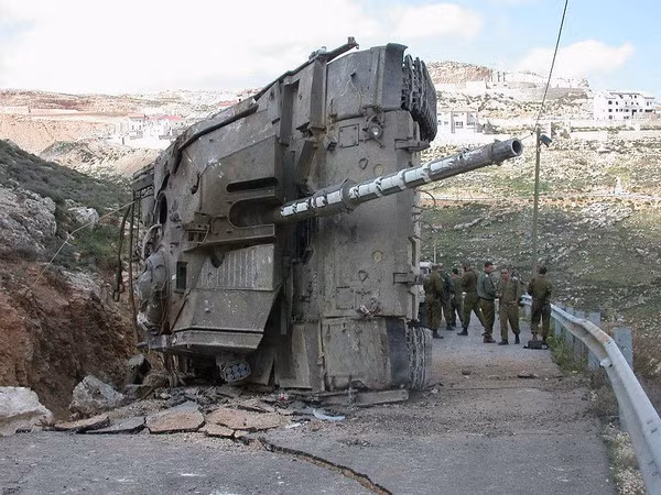 Lại một xe tăng Merkava IV khác của Israel bị lật nghiêng trên đường gây hư hại nghiêm trọng tới mặt đường. Nguồn ảnh: Rumble.