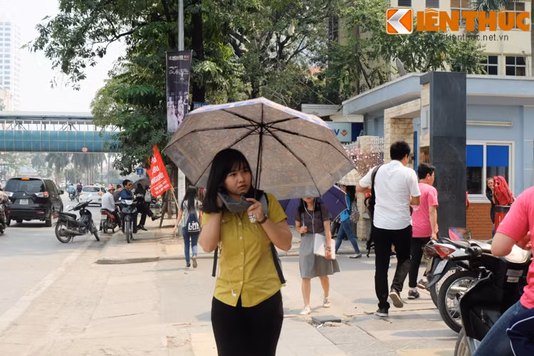 Các cô gái không chỉ che ô, còn cẩn thận bịt thêm khẩu trang để tránh khói bụi, nắng rát ảnh hưởng đến làn da.