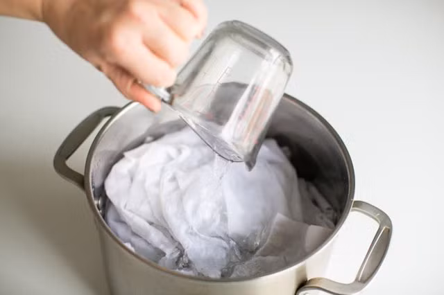 Để loại bỏ vết bẩn trên áo trắng bạn hãy ngâm áo trắng của mình trong một nồi nước nóng có pha giấm. Sau một đêm, mang ra giặt bình thường. Cách làm này sẽ giúp áo trắng của bạn không còn một vết bẩn nào như khi bạn dùng chất tẩy.