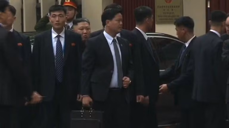 "Bức tường vệ sĩ" vây xung quanh chủ tịch Kim Jong-un mỗi khi ông bước lên và xuống xe. Nguồn ảnh: VTV.