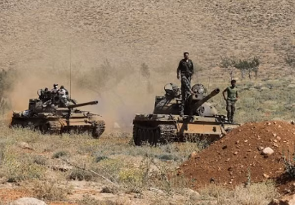 Các chiến binh Hezbollah trên xe tăng tại khu vực mới giải phóng ở vùng núi biên giới giáp với Syria. Ảnh: FNA.