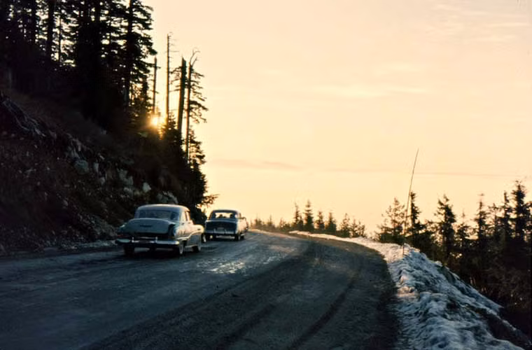 Lái xe giữa lúc trời sáng sớm trên con đường men theo núi Seymour ở Vancouver.