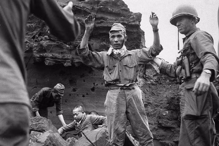 Các tù binh Nhật đầu tiên giơ tay đầu hàng khi họ chui ra từ một cái hang ở Iwo Jima vào ngày 5/4/1945. Nhóm này đã lẩn trốn vài ngày. Nguồn ảnh: AP.