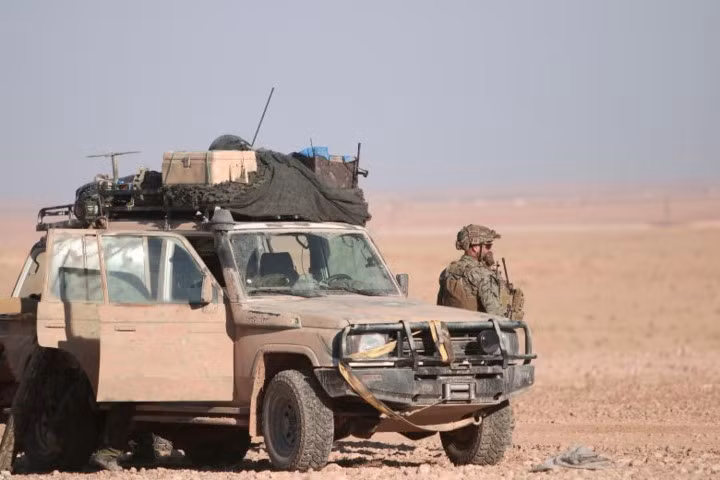 Quân nhân Mỹ đứng cạnh chiến xa, ở phía bắc thành phố Raqqa. Nguồn ảnh: Reuter.