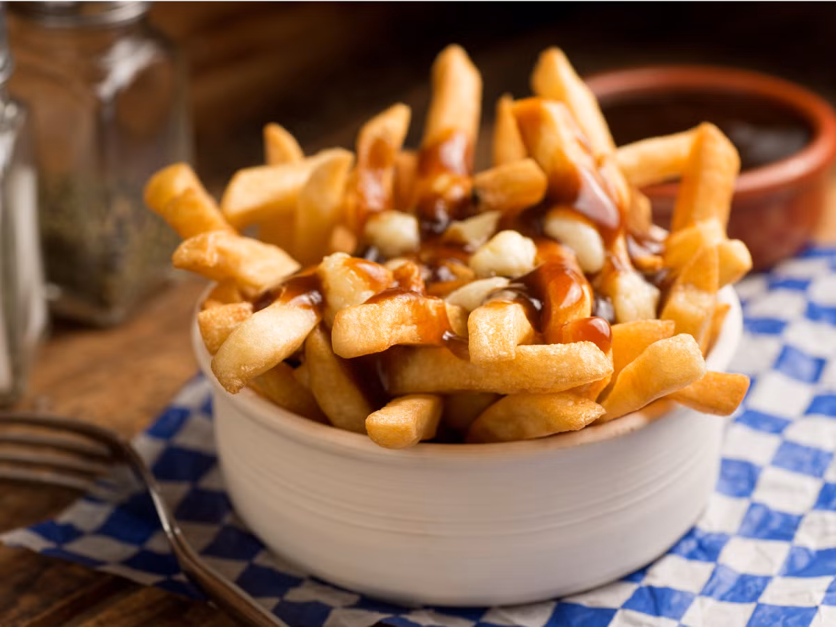 Khi đến La Banquise, Montreal, thực khách nên thưởng thức món Poutine với nước sốt thịt, pho mát sữa đông rưới lên khoai tây chiên.