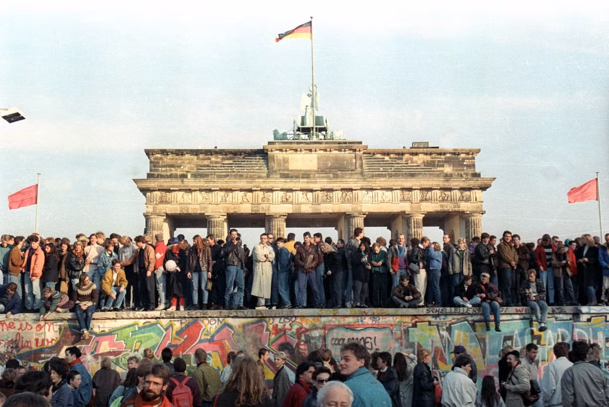 Rất đông người dân tụ tập tại Bức tường Berlin để ăn mừng thời khắc lịch sử, đánh một dấu mốc quan trọng trong lịch sử thế giới hiện đại. Ảnh: STR New.