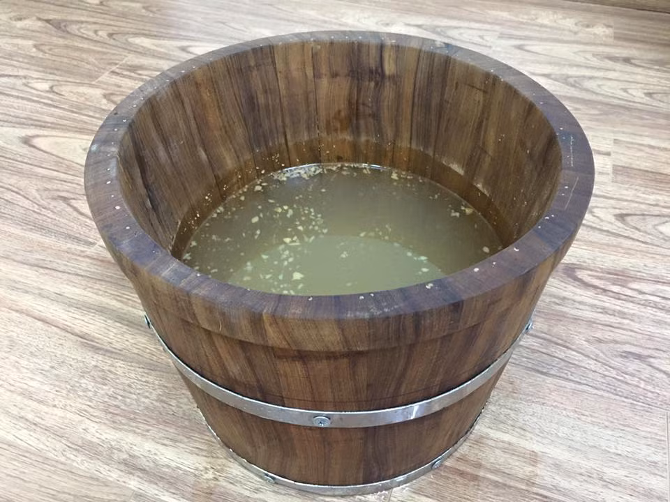 Bạn hãy đun sôi một nồi nước và đập nhỏ một nhánh gừng cho vào nồi nước sôi, đun tiếp 20 phút nữa. Đợi cho nước nguội, dùng nước đó để ngâm chân 2 lần/ngày. Ảnh: Zing.