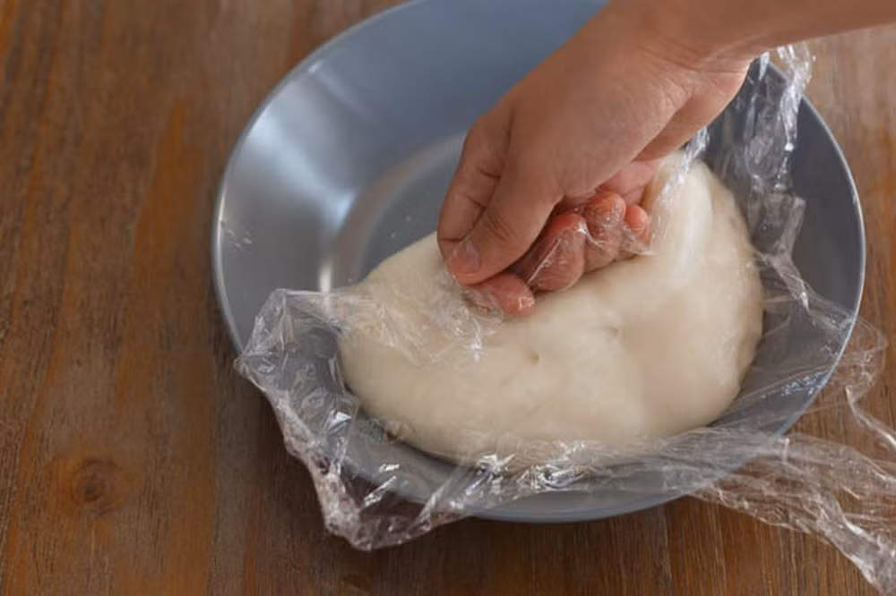 Ấn bột một lúc rồi dùng màng thực phẩm bọc lại, để bột nghỉ 10 phút, sau đó lại tiếp tục công đoạn nhào bột.