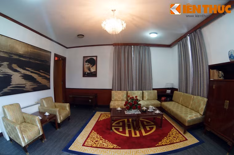 Bên trái căn phòng là nơi tiếp khách với các bộ bàn ghế sofa bọc vải vàng. Bức tường bên trái có bức ảnh khổ lớn về bãi biển miền Trung.