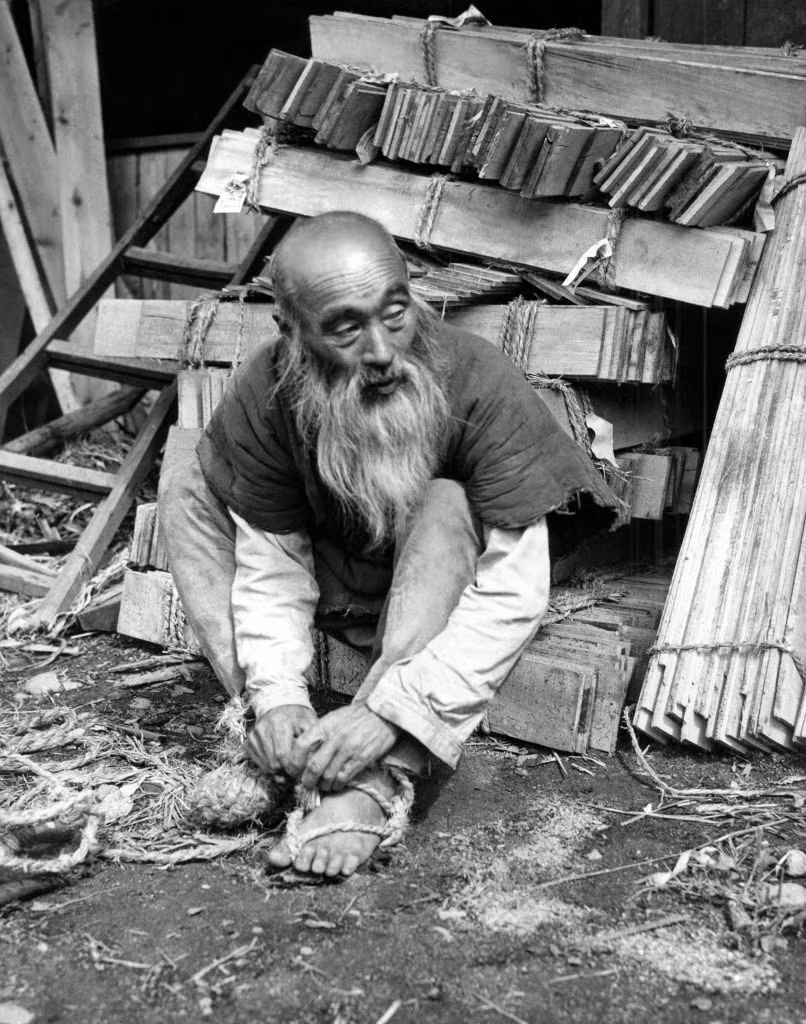 Ông Hikosaku Sakamoto, một nông dân 63 tuổi tháo chiếc dép rơm của mình sau khi chạy bộ 125 dặm từ Shirakawa đến Tokyo để quảng bá cho một lễ hội tại đền thờ ở quê nhà.