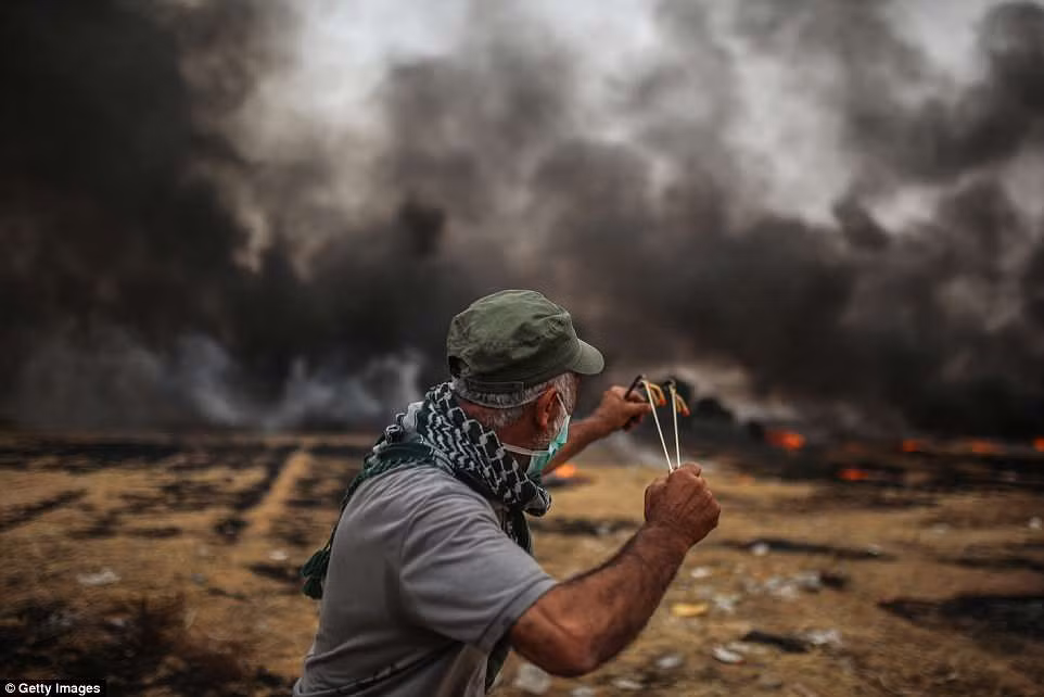 Một người biểu tình Palestine đứng gần hàng rào biên giới Israel. Hiện chưa có thông tin về thương vong bên phía Israel.
