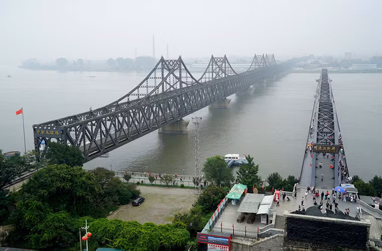 Cầu Hữu nghị (bên trái bức ảnh) nối liền hai thành phố Sinuiju và Đan Đông là tuyến đường thương mại chính của hai nước.
