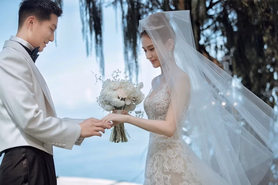Đậu Kiêu đeo nhẫn cho Hà Siêu Liên. Nhẫn cưới của tiểu thư nhà họ Hà đính kim cương hồng. Khách mời chia sẻ với On, lễ cưới diễn ra trong không khí ấm áp, xúc động, lãng mạn và tràn ngập tiếng cười. Gia đình, bạn bè và đồng nghiệp không ngớt lời chúc phúc dành cho tân lang, tân nương.
