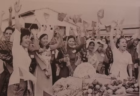 Phụ nữ quận 4 ở Sài Gòn mang cờ, hoa quả ra đường phố chào mừng quân giải phóng sáng ngày 30/4/1975.