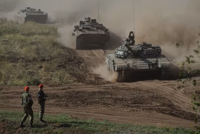 Các xe tăng T-72, xe thiết giáp BMP-2 của Quân đội Nga hối hả vào thao trường tập trận.