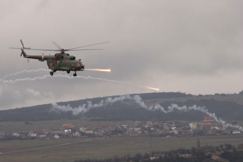 Trong khi đó, chiếc trực thăng Mi-8 đang phóng rocket liên hoàn từ trên không trong tình huống chống khủng bố ở Simferopol, Crimea.