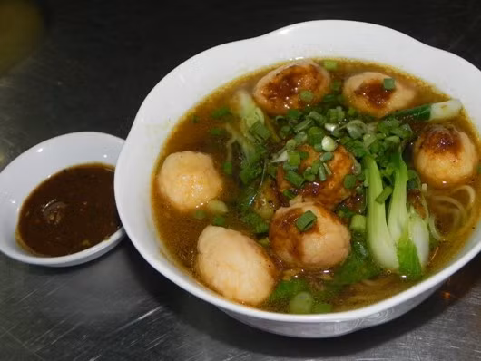 Mì cà ri cá viên hấp dẫn thực khách với những sợi mì vàng ươm, những viên cá vàng chiên vàng điểm xuyết nước sốt cà ri đậm màu, rau cải xanh ngắt. Ảnh: An Huỳnh.