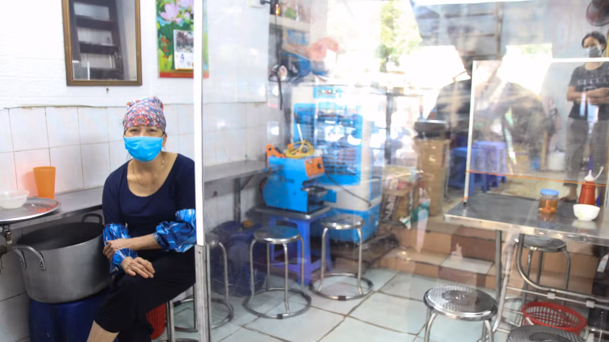 Hàng ăn sáng trên phố Phủ Doãn đìu hiu ngóng khách buổi sáng cuối tuần. Quán dựng vách ngăn, khuyến khích khách mua mang đi, giao hàng tận nơi