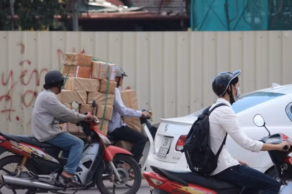 Mọi chỗ trống trên xe máy được người điều khiển tận dụng triệt để để nhét hàng hóa.