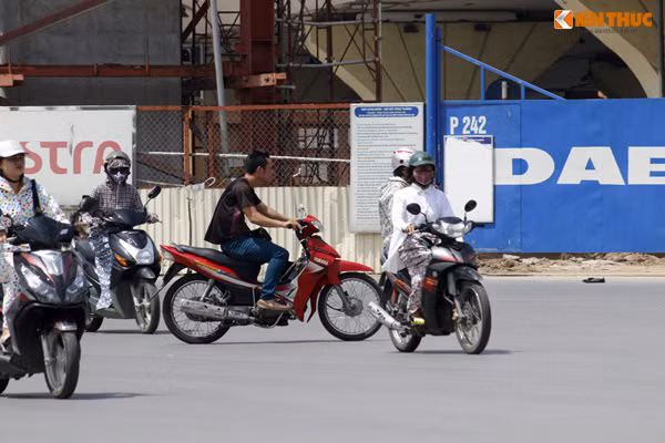 Cho dù đèn báo tín hiệu giao thông đang bật đỏ để phương tiện từ hướng Phạm Hùng đi Phạm Văn Đồng (Hà Nội) di chuyển nhưng nam thanh niên không đội mũ bảo hiểm vẫn tăng ga, luồn lách xe qua các phương tiện.