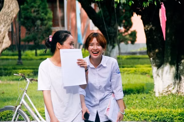 Hai nữ sinh xinh xắn cười sảng khoái và chia sẻ cảm xúc vui sướng với nhau khi làm được bài môn thi Ngoại ngữ. Ảnh: Mạnh Hưng.