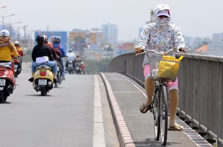 Vào những ngày chuyển giao giữa mùa nắng và mưa, nhiệt độ ngoài đường tăng cao khiến người dân phải trùm kín khi ra đường.
