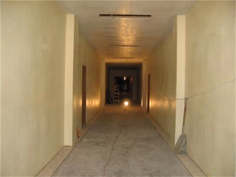 Vật tư xây dựng như máy xúc, thang và đèn vẫn còn nằm ngổn ngang ở cuối hành lang.