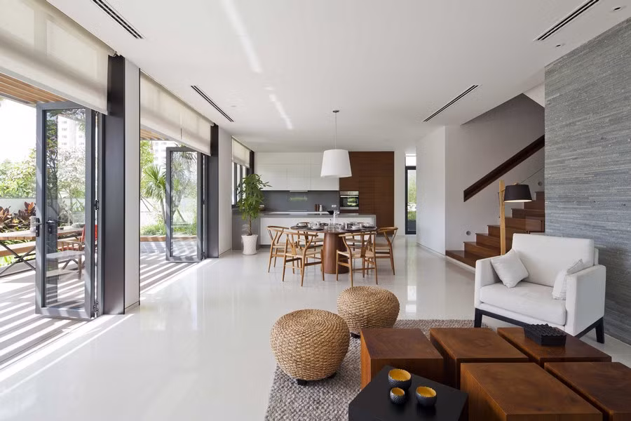 Không gian dành riêng cho việc tiếp khách sử dụng đồ nội thất chất liệu tự nhiên như bàn gỗ, đèn gỗ, ghế và thảm đan bằng lục bình và cói.