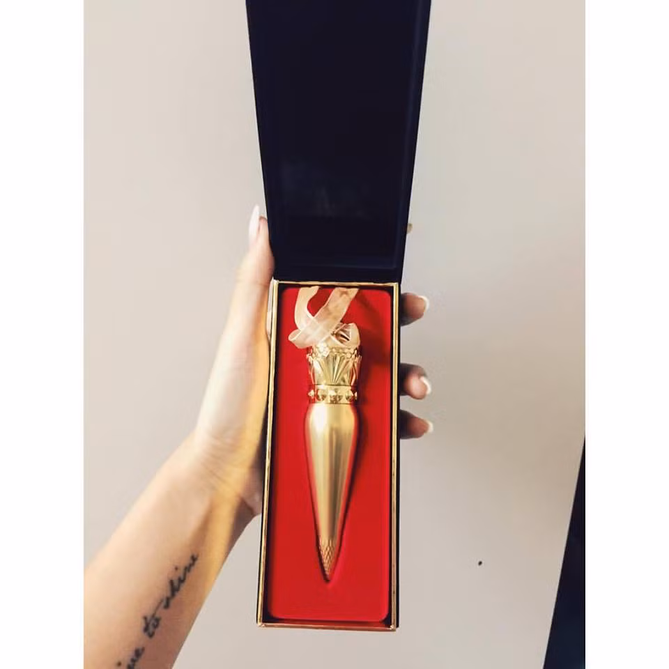 Cô ca sĩ chọn son lì, tông Diva rực rỡ. Nhận xét của Emily về thỏi son là thiết kế rất đẳng cấp, đánh lên môi rất mượt. Màu đỏ cam tôn da nhưng không bị khô môi như những loại son lì khác.