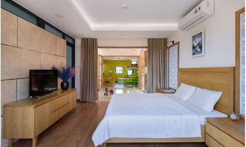 Phòng ngủ cũng khá nhã nhặn với các đồ nội thất gỗ và sơn tường màu trắng.