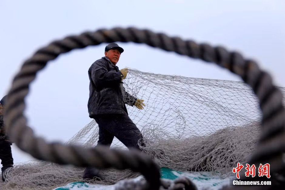 Một ngư dân chuẩn bị giăng lưới để đánh cá dưới hồ.