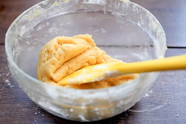 3. Bánh dứa. Nguyên liệu: Bơ, phô mai bò cười, sữa đặc, sữa tươi, đường, lòng đỏ trứng, bột mì. Cho bơ, phô mai, đường vào âu đánh đều. Cho tiếp 1 lòng đỏ trứng vào đánh đến hoà quyện. Cho tiếp sữa đặc và sữa tươi đánh đến hoà quyện. Ảnh: Monngon.tv.