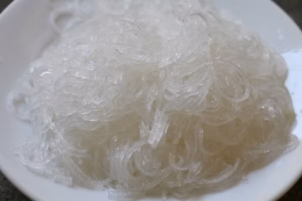Hành tây cắt mỏng, ngâm với đá lạnh và dấm ăn trong khoảng 2 tiếng cho hết vị hăng. Miến ngâm nước lạnh cho mềm, trụng nhanh qua nước sôi rồi xóc ráo nước, trộn với 1 muỗng canh dầu ô liu. Ảnh: monngon.tv.