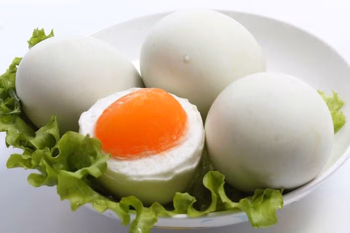 Trứng vịt muối luộc chín, lấy lòng đỏ mài nhuyễn. Trộn vào cơm ớt bột, màu điều, bột năng, muối, sả bằm, ngũ vị hương, trứng vịt muối, trứng gà đánh tan, bột ngọt, trộn lại cho đều, vắt thành từng nắm cho chặt. Ảnh: Thucthan.com.