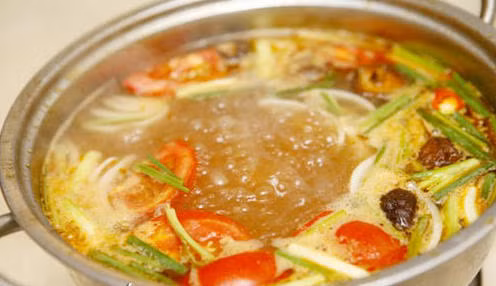 Măng chua thái mỏng, luộc 2 lần cho ra hết vị hăng và để ráo nước. Tiếp đến, cho dầu ăn lên chảo, sau đó trút măng vào xào sơ. Bắc nồi lẩu lên bếp, cho khoảng 1 muỗng dầu ăn, đợi dầu nóng cho tỏi băm vào phi thơm, sau đó trút thịt vịt vào xào cho săn. Khi thịt vịt đã săn, bạn cho sa tế vào. Ảnh: giadinh.tv.