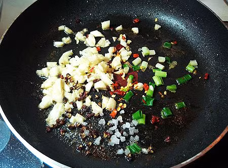 Chuẩn bị 1 nồi nước, đun sôi thì thả đùi gà vào đun cho đến khi nước sôi trở lại, lật đùi gà rồi vớt ra để ráo. Cho dầu ăn vào chảo đun nóng, lần lượt xào với hành tím, tỏi, sả, gừng, ớt, bột nghệ. Ảnh: yeunoitro.com.