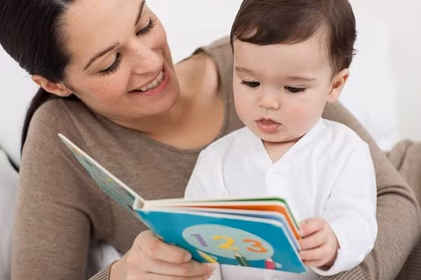 2. Đọc sách cho bé nghe. Với bé chậm nói, đây là việc làm rất tốt để bé có thể phát triển tư duy về mọi mặt, đặc biệt là tư duy ngôn ngữ. Hãy lựa chọn những câu chuyện có nội dung nhẹ nhàng, có ngôn từ đẹp và đọc cho bé nghe trước khi đi ngủ như một thói quen. Ảnh: Suckhoegiadinh.com.