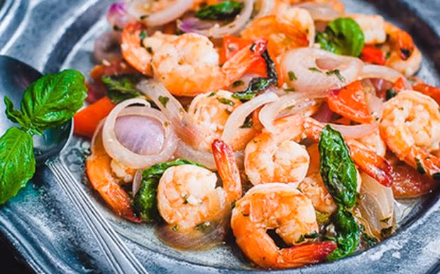 Cho rau húng quế thái nhỏ vào, kế đó, cho phần tôm xào sẵn vào đảo cùng cho đến khi tôm chín hẳn. Sau cùng mới cho rau húng để nguyên lá vào đảo lại trong giây lát rồi tắt bếp. Ảnh: Baophapluat.vn.