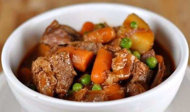 Khi thịt bò mềm, mình vớt thịt ra, lượt bỏ xác hành tỏi, cà chua.... Nêm hạt nêm từ thịt thăn và xương ống mới cho vừa ăn. Sau đó cho thịt vào lại nồi cùng với khoai tây, cà rốt... Dùng nóng kèm với bánh mì, pasta hoặc cơm. Ảnh: Baophapluat.vn.