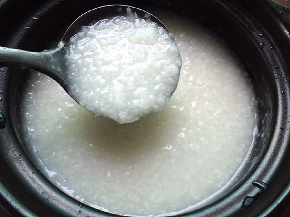 Đậu Hà Lan sơ chế, cho vào nồi, đổ ngập nước, nấu chín mềm. Sau khi đậu chín, nghiền nát đậu bằng tay. Hành đập dập, phi thơm, trút thịt heo đã băm sẵn vào xào sơ qua, nêm gia vị vừa đủ. Thịt lợn chín tới, cho vào cháo trắng đảo đều.