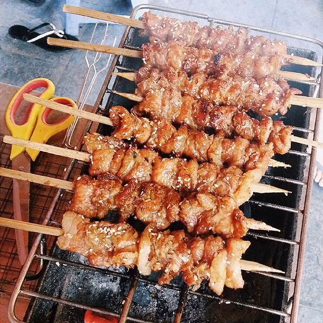 Ướp phần thịt đã rửa sạch, thái miếng với riềng, sả, nghệ, đường, muối, nước cốt chanh, xì dầu, vừng trộn thịt cho đều. Xiên thịt: Khéo léo xiên những dải thịt vào que tre. Cho thịt lên bếp than nướng khoảng 8-10 phút, vừa nướng vừa trở thịt để thịt chín đều, không bị cháy. Ảnh: thannuongsach.com.