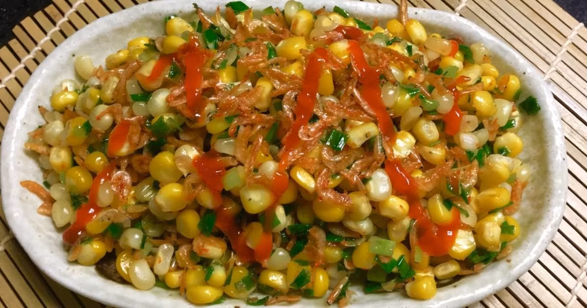 4. Bắp xào tôm khô, xúc xích. Nguyên liệu: Bắp ngô, hành tím, hành lá, xúc xích, tôm khô, nước mắm, đường, bơ. Phi thơm hành tím. Cho bắp ngô vào xào, thêm nước, xúc xích, tôm khô theo thứ tự rồi nêm gia vị, tắt bếp. Ảnh: cookpad.com.