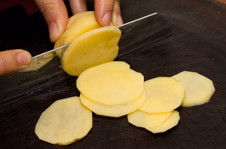 2. Snack khoai tây - khoai tây lắc phô mai. Nguyên liệu: Khoai tây, bột phô mai, dầu ăn, muối. Khoai tây gọt vỏ cắt lát thật mỏng ngâm vào thau nước muối loãng 30 phút. Rửa lại thật sạch cho đến khi nước trong.