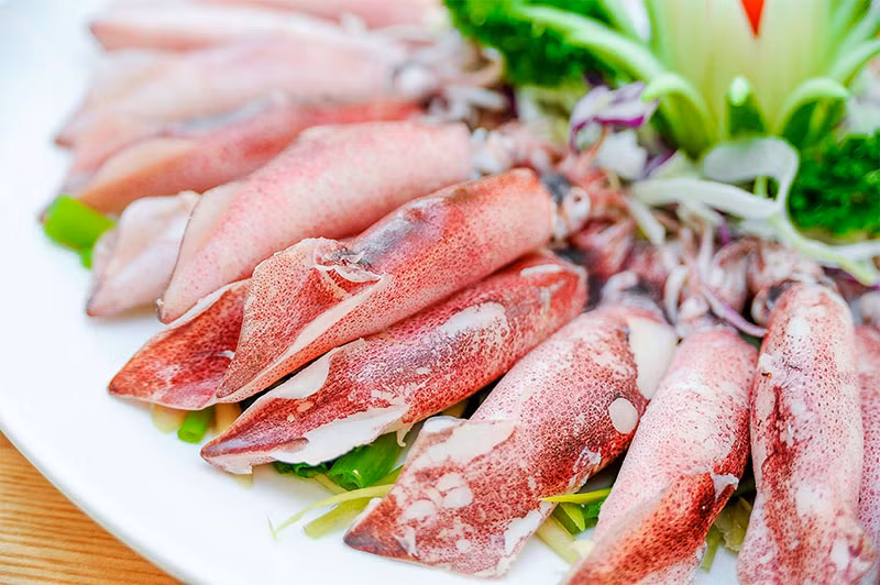 Bột đao cán nhỏ, mịn dùng làm bột áo. Mỡ khổ rửa sạch, luộc chín, thái hạt lựu. Trộn thịt giã nhuyễn với nấm, mộc nhĩ, mỡ khổ, miến, hành băm nhỏ, nước mắm cô đặc, mì chính, tiêu quật kỹ cho dẻo quánh, nhồi vào bụng mực, đem hấp chín. Ảnh: haisancoto.com.