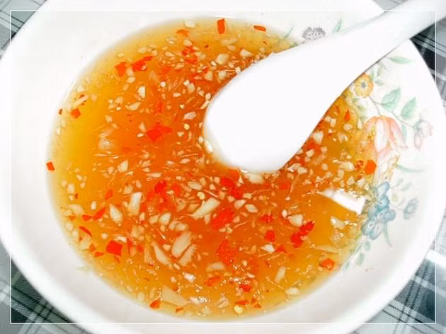 2. Nước chấm bún thịt nướng. Giấm nước mắm nước đun sôi để nguội. Sau khi nêm nếm vừa ăn cho thêm tỏi băm, ớt băm và ít tiêu xay. Pha theo công thức: 1 giấm + 1 đường + 1/2 mắm + 2 nước (nước đun sôi để nguội) 1 đến 2 muỗng cà phê nước cốt chanh tỏi và ớt băm. Ảnh: Emvaobep.com.