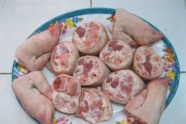 4. Giò heo hầm mía. Nguyên liệu: Bắp giò, khúc mía, nước dừa tươi, cà rốt, củ sắn, cải chua, ngò rí, tỏi băm, xí muội, sa tế tôm, đường, hạt nêm, muối, màu điều. Thịt rửa sạch, ướp với số gia vị trên (trừ màu điều). Để 30 phút cho thịt thấm gia vị. Ảnh: Monngon.tv.