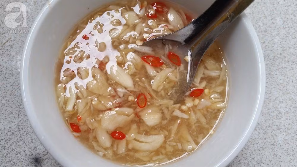 Dưa chuột ngâm muối, cắt lát, để nguyên vỏ sẽ giòn ngon hơn. Cho 2 nguyên liệu này vào tô, trộn với chút bột canh cho ngấm. Chuẩn bị nước mắm chua ngọt: 2 thìa canh nước mắm + 2 thìa cà phê nước lạnh + nửa quả chanh + tỏi, ớt băm + 1 thìa đường. Ảnh: phunusuckhoe.vn.