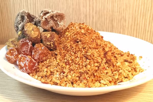 Cho hết các thành phần đường, ớt, ô mai xay vào chảo và đun lửa vừa phải. Đảo liên tục để cho hỗn hợp khô lại là được. Ảnh: hoaquaonline3mien.com.